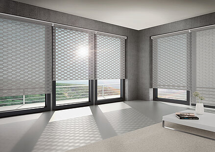 Wohnzimmer mit grossen Fenstern und geometrisch gemusterten Doppelrollos vom Typ „Logan“ von MHZ, die ein gleichmässiges Lichtmuster auf dem Boden erzeugen.